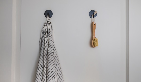 Kā piestiprināt vannas istabas piederumus ar piesūcekņiem, lai tie nekristu?